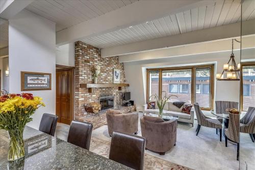 a living room with a table and chairs and a fireplace at Lovely Aspen Condo with Mountain Views & Hot Tub in Aspen