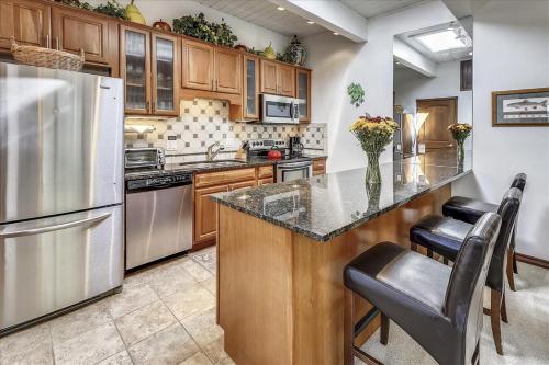 a kitchen with stainless steel appliances and wooden cabinets at Lovely Aspen Condo with Mountain Views & Hot Tub in Aspen