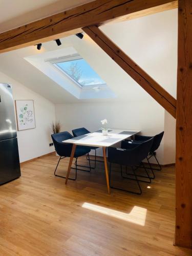 comedor con mesa, sillas y tragaluz en Ferienwohnung Sternblick, en Marktoberdorf