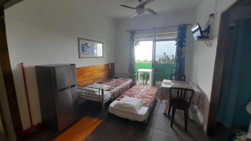a living room with a couch and a refrigerator at Fare Arana Mooréa Guesthouse in Atiha