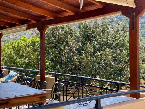 a balcony with a table and chairs and a tree at Astali Villa in Stalida