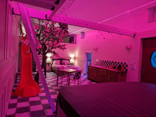 une chambre rose avec un lit et un vase avec des fleurs dans l'établissement De l autre coté du miroir, à Mazingarbe