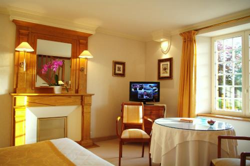 濱海莫厄朗的住宿－科塔格莊園酒店，客厅配有桌子和壁炉