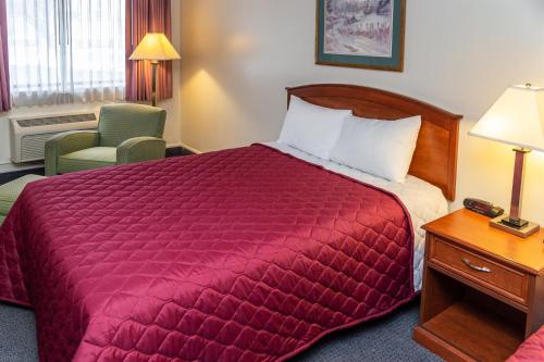 a hotel room with a bed and a chair at Country Village Motel in Manti