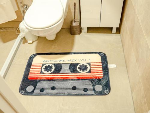 a bathroom with a rug on the floor next to a toilet at Andar`s people in Sarajevo