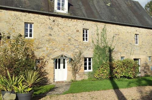 an old stone house with a white door at Maison Normandie proche mer in Cambernon
