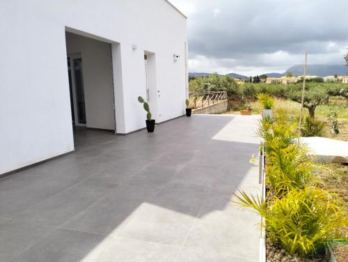 a patio of a white house with plants at Le maree di Cofano in Custonaci