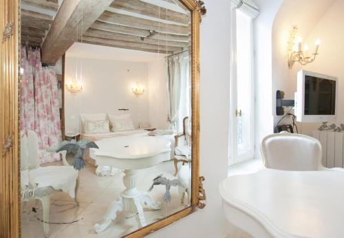 une salle de bain avec un miroir et un lavabo dans l'établissement Les heures parisiennes, à Paris