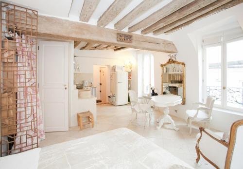 une cuisine et une salle à manger avec une table et des chaises dans l'établissement Les heures parisiennes, à Paris