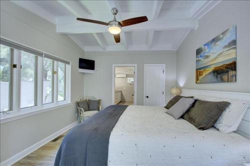 ein Schlafzimmer mit einem großen Bett und einem Deckenventilator in der Unterkunft Beachcomber Cottage in Jekyll Island