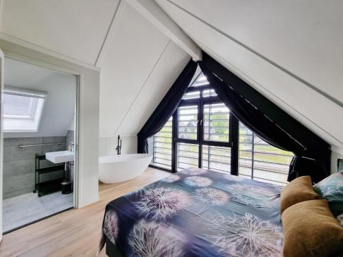a bedroom with a bed and a tub and a window at Villa in Balk with Private Jetty on Slotermeer in Balk