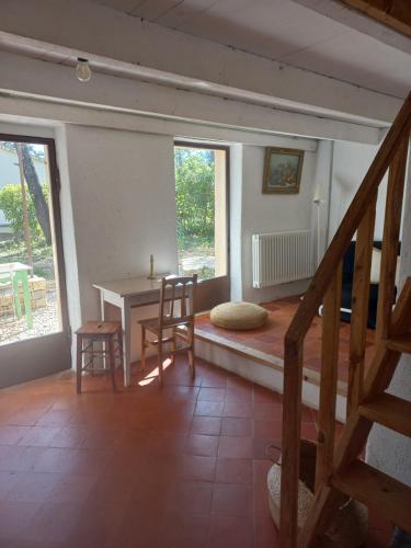 a room with a table and chairs and a staircase at Un cabanon en Provence in Auriol