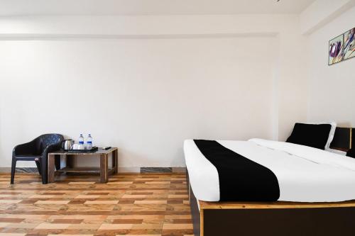 a bedroom with a bed and a chair and a table at HOTEL O SHIVA RESIDENCY INN in Rānchī