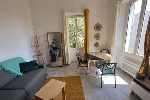 un salon avec un canapé bleu et une table dans l'établissement Studio cosy en coeur de ville, à Ajaccio