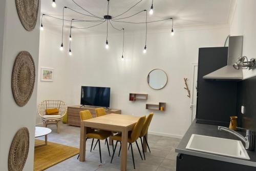 une cuisine et un salon avec une table et des chaises dans l'établissement T2 cossu et calme en plein coeur d'Ajaccio, à Ajaccio