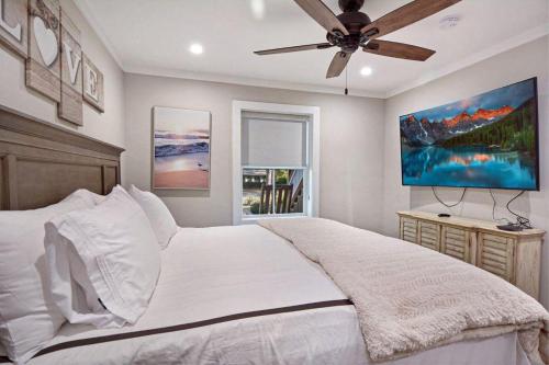 ein Schlafzimmer mit einem weißen Bett mit Deckenventilator in der Unterkunft Beach Memories in Jekyll Island