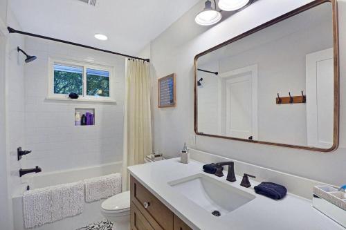 ein weißes Badezimmer mit Waschbecken und Spiegel in der Unterkunft Beach Memories in Jekyll Island