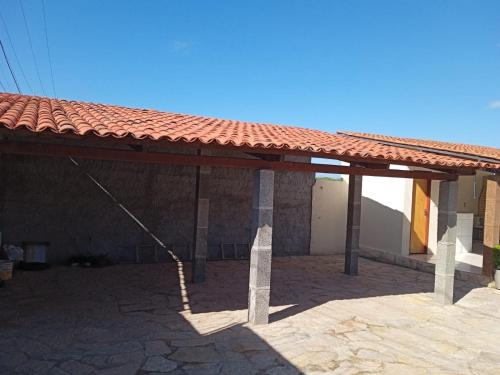 a building with a red roof with a stone patio at Condominio Nina in Icapuí