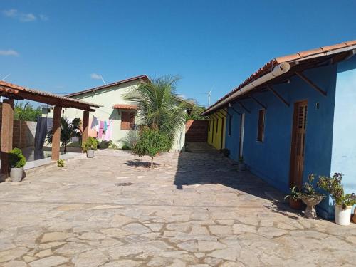 a courtyard of a house with a blue and yellow building at Condominio Nina in Icapuí