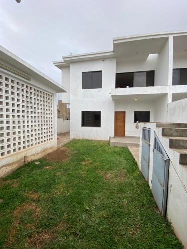 a white house with a yard in front of it at Villa esperança in Fombeni