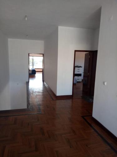 an empty room with white walls and wooden floors at Villa esperança in Fombeni