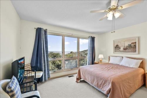 una camera da letto con un letto e una grande finestra di Gravina's Morningside a Jekyll Island
