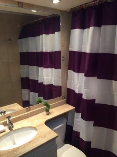 a bathroom with a toilet and a sink and a mirror at Dpto frente a la playa la Herradura con Piscina in Coquimbo