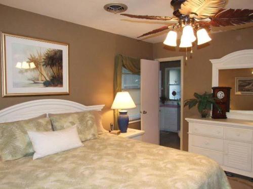 ein Schlafzimmer mit einem Bett und einem Deckenventilator in der Unterkunft Island Time in Jekyll Island