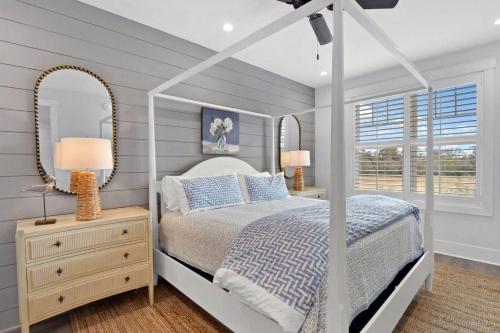 a bedroom with a canopy bed and a mirror at Moorings 206 in Jekyll Island