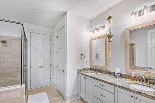 a bathroom with a sink and a shower and a mirror at Moorings 107 in Jekyll Island