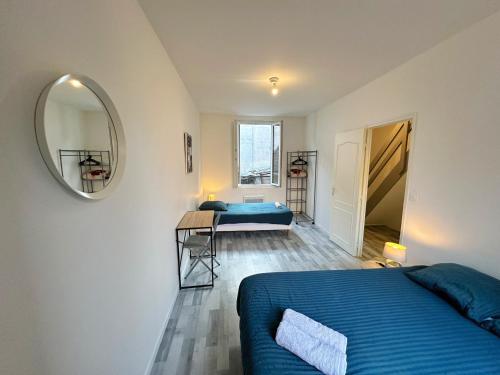 une chambre avec un lit bleu et un miroir dans l'établissement L'Évasion en Bord de Seine, à Bray-sur-Seine