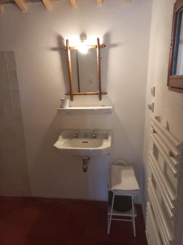 a bathroom with a sink and a mirror and a stool at Un cabanon en Provence in Auriol