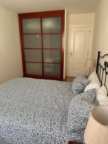 a bedroom with a bed and a glass door at Living Gijon & Parking in Gijón