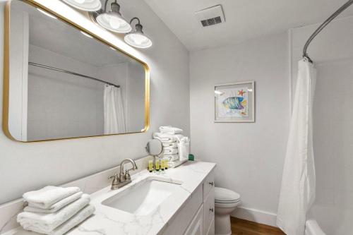 a white bathroom with a sink and a mirror at Villa 129 in Jekyll Island