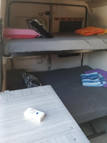 une chambre avec deux lits superposés et une table dans l'établissement Van aménagé 3 couchages sans SANITAIRE proche de la plage, à Mauguio