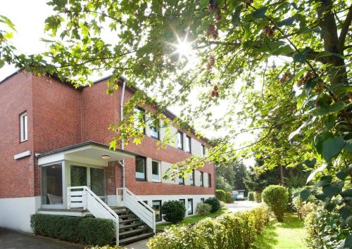 a red brick building with a porch and stairs at Hotel Cockpit in Hamburg