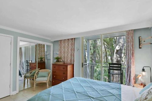 a bedroom with a bed and a room with a window at Villa 453 in Jekyll Island
