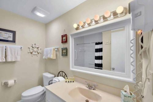 a bathroom with a sink and a toilet and a mirror at Villa 453 in Jekyll Island