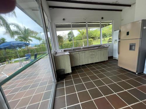 a kitchen with a large window and a refrigerator at Finca La Ranchera No. 2 in Tarso