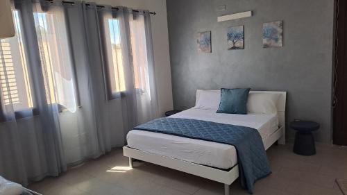 a small bedroom with a bed and two windows at Marazur in Poggiardo