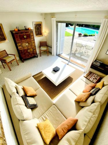 un salon avec un canapé et une grande fenêtre dans l'établissement Villa Chic & Zen, Jungle Provençale et Piscine de 14m pour 1 à 6 personnes, à Cassis