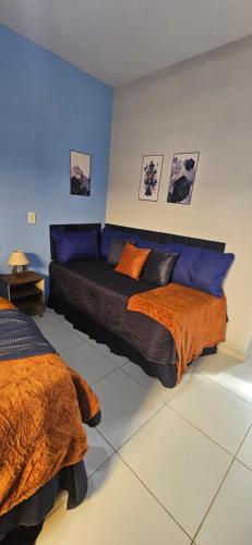a bedroom with two beds with orange and blue at Studio Cinza em frente à praia in Aracaju