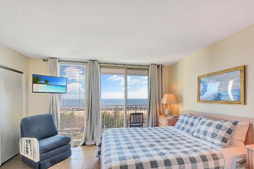a bedroom with a bed and a chair and a window at Villa 107 in Jekyll Island