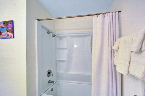 a bathroom with a shower with a white shower curtain at Villa 107 in Jekyll Island