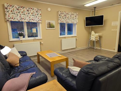 a living room with couches and a flat screen tv at Sofielund Vandrarhem & Camping in Sala