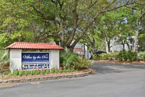 a sign for a villa by the sea with flowers at Villa 131 in Jekyll Island
