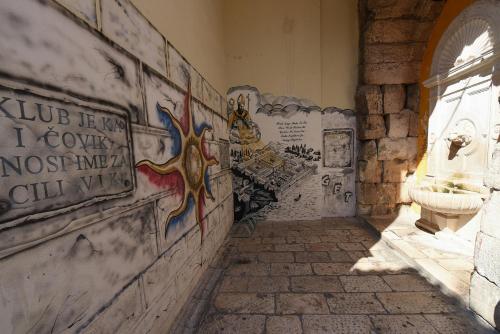 a hallway with graffiti on the walls of a building at Pylon Rooms in Split