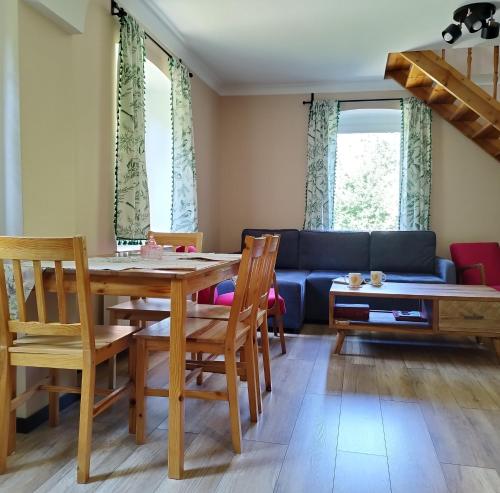 a living room with a table and a blue couch at Apartamenty u Gołębiewskich in Stara Kamienica