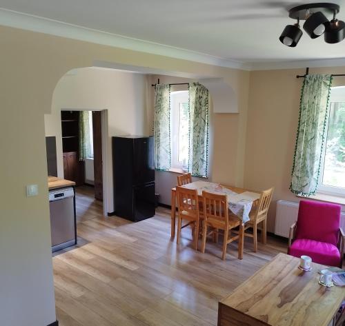 a kitchen and living room with a table and chairs at Apartamenty u Gołębiewskich in Stara Kamienica