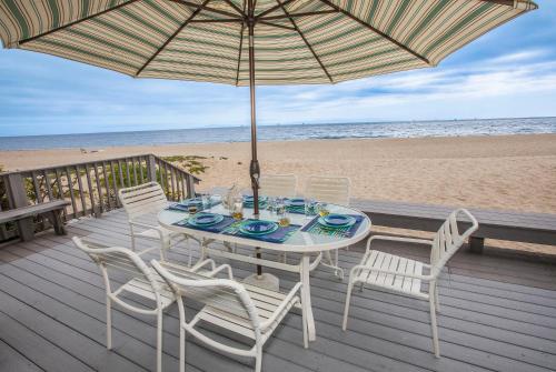 une table avec des chaises et un parasol sur la plage dans l'établissement Seahorse Retreat by Paradise Retreats, à Carpinteria